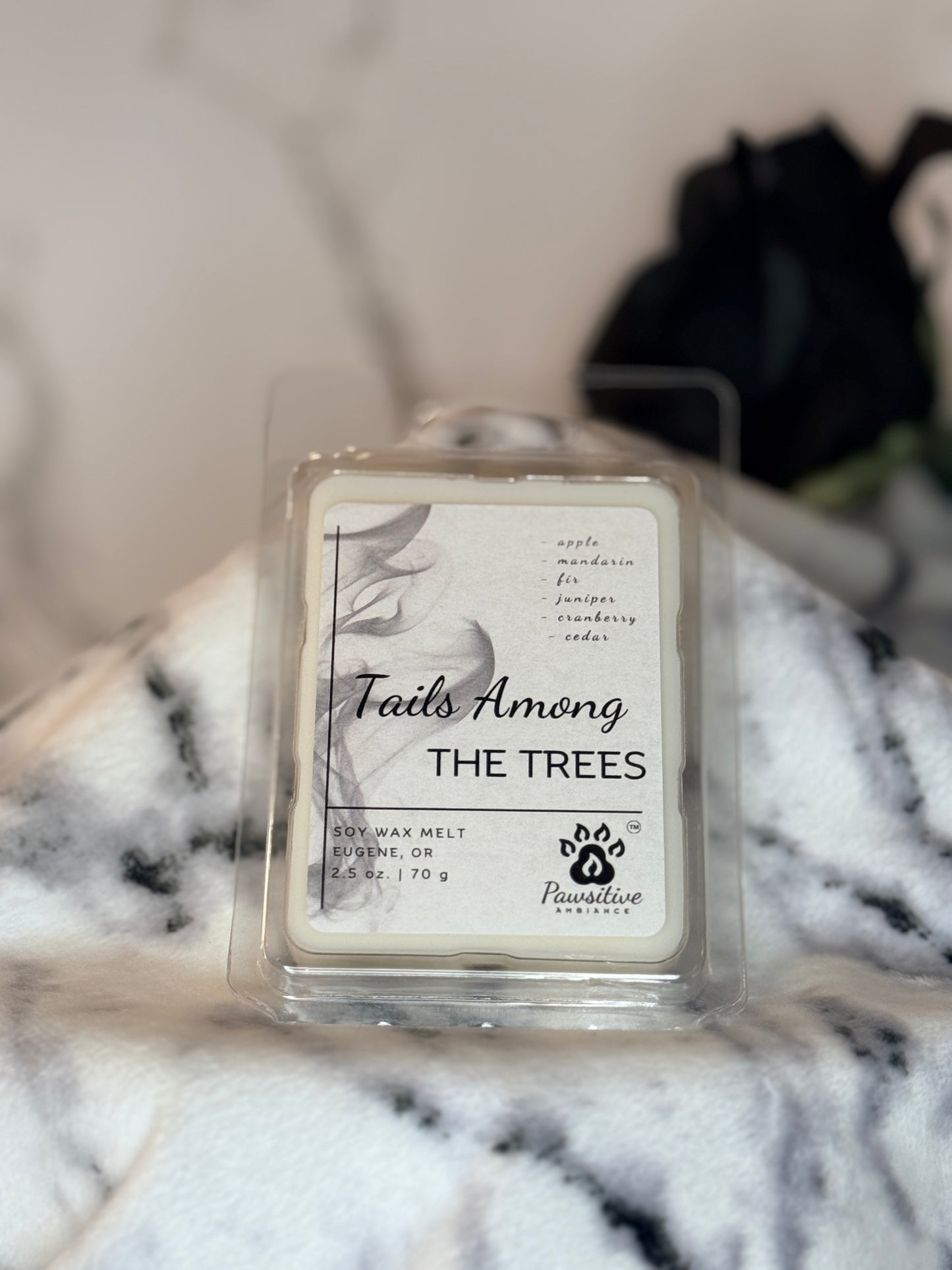 Hand-poured wax melt labeled Tails Among the Trees featuring notes of apple, mandarin, fir, juniper, cranberry, cedar. 2.5 oz. Manufactured by Pawsitive Ambiance.