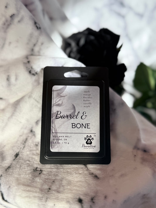 Soy wax melt labeled Barrel & Bone featuring notes of apple, orange, bourbon, butter, vanilla and maple.  Made in Eugene, Oregon. 2.5 oz. Manufactured by Pawsitive Ambiance.