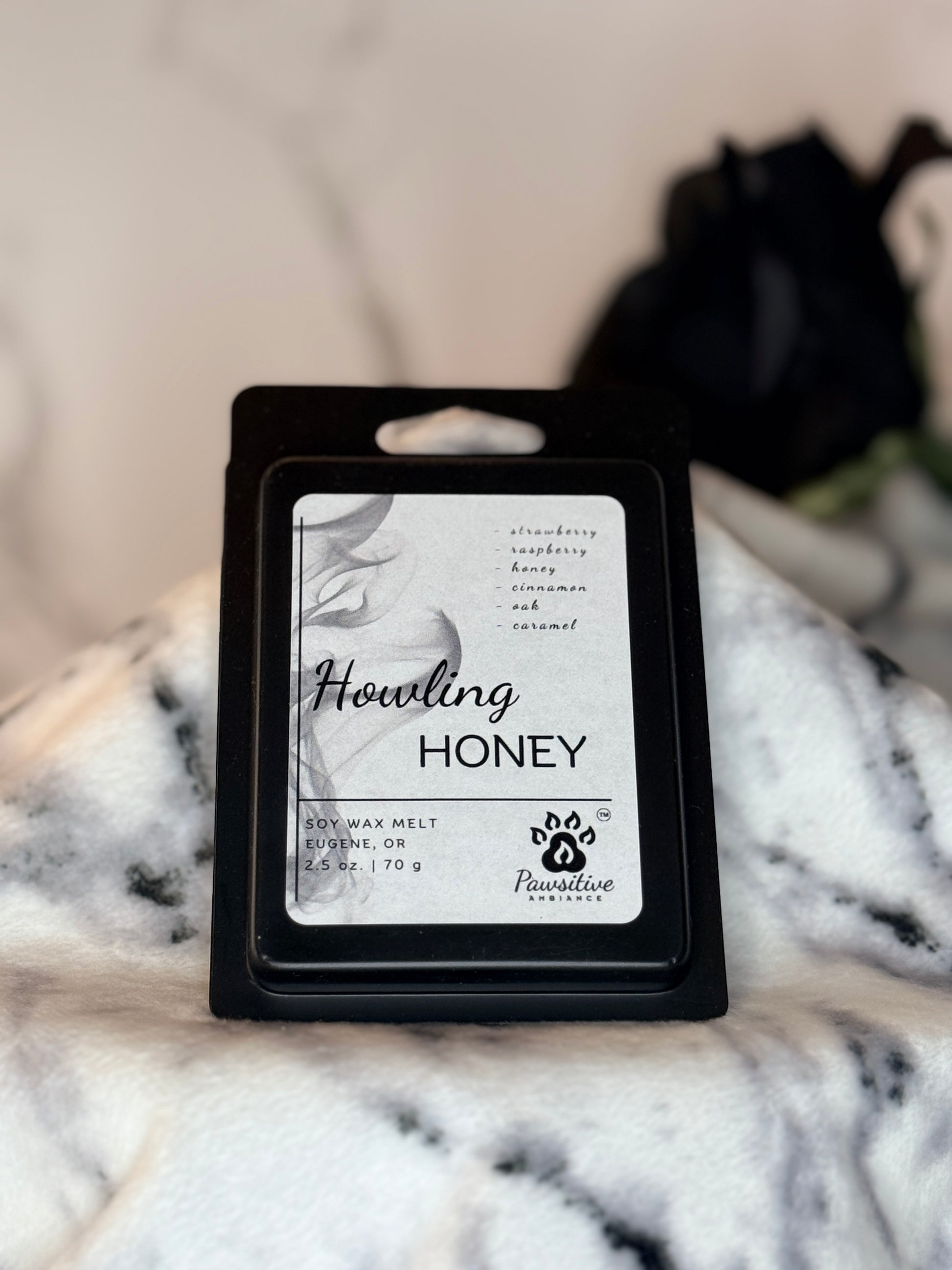 Hand-poured soy wax melt labeled Howling Honey featuring notes of strawberry, raspberry, honey, cinnamon, oak and caramel.  Made in Eugene, Oregon. 2.5 oz. Manufactured by Pawsitive Ambiance.