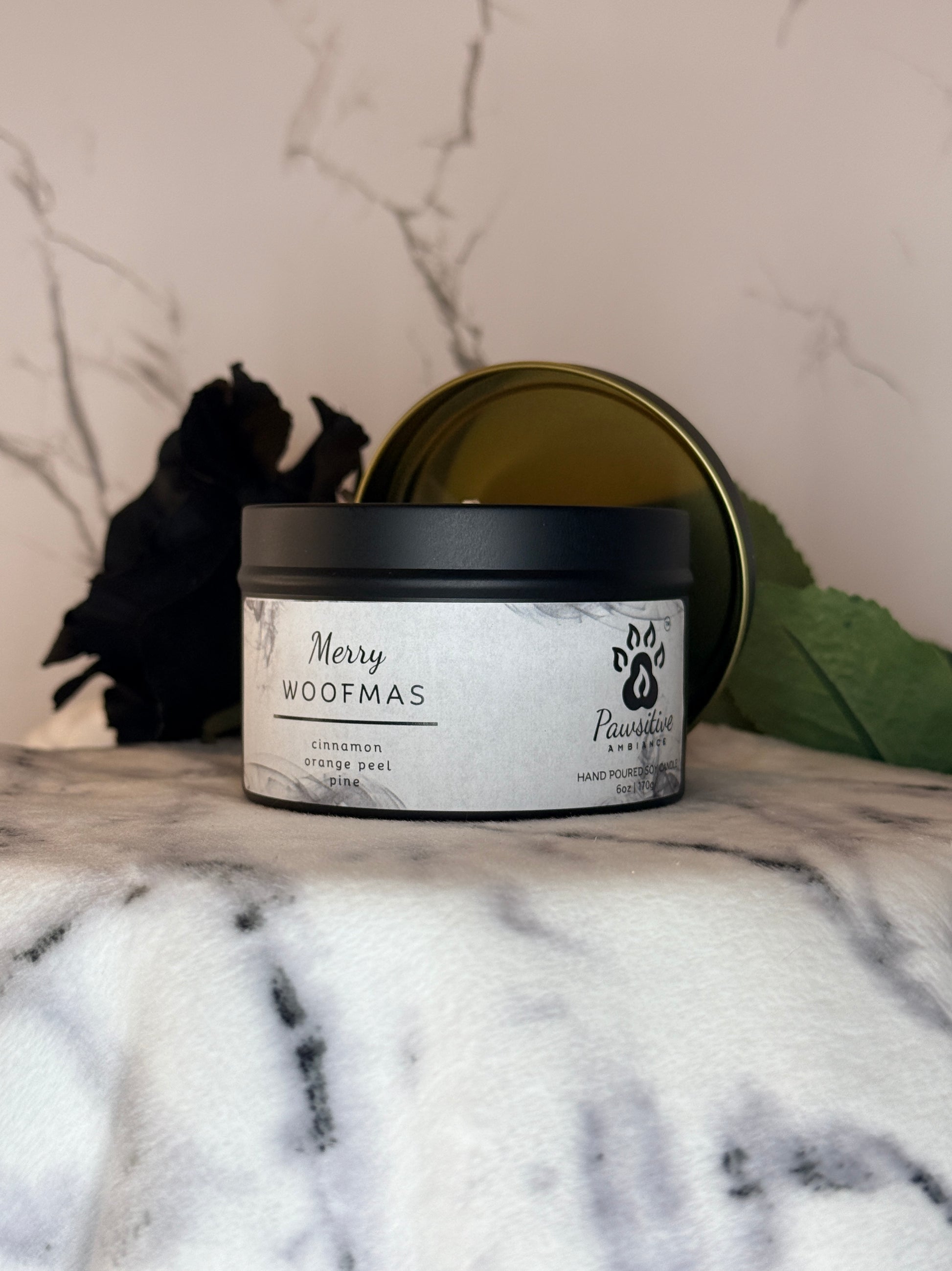 Hand-poured soy candle labeled Merry Woofmas featuring notes of cinnamon, orange peel and pine.  6 oz. Manufactured by Pawsitive Ambiance.