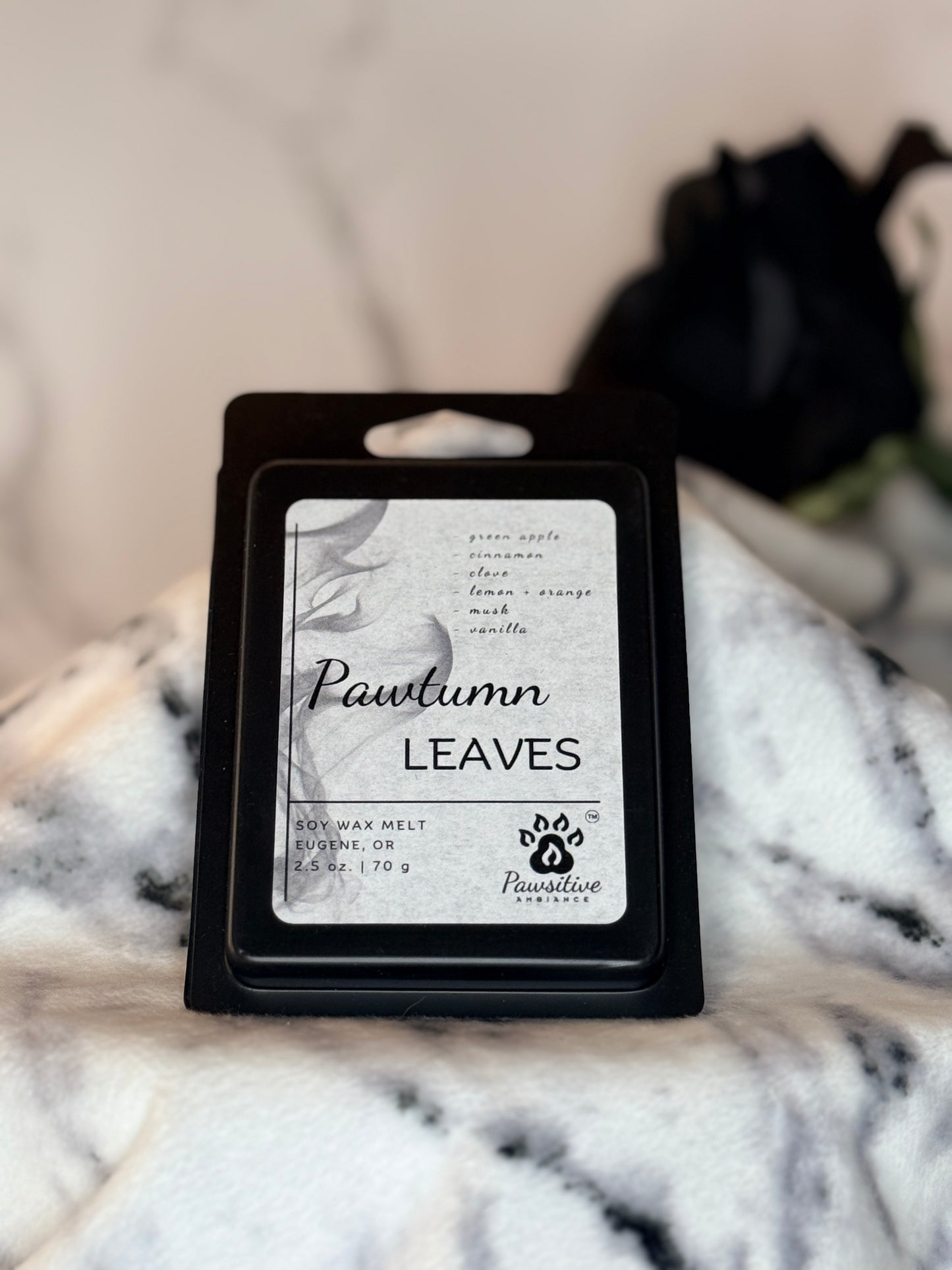 Hand-poured soy wax melt labeled Pawtumn Leaves featuring notes of green apple, cinnamon, clove, lemon + orange, musk, vanilla.  Made in Eugene, Oregon. 2.5 oz. Manufactured by Pawsitive Ambiance.
