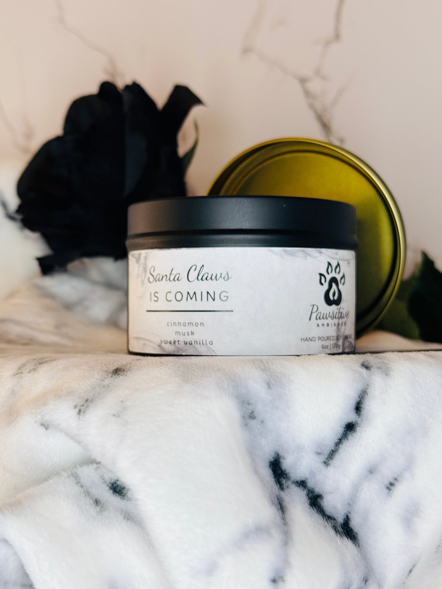 Hand-poured candle labeled Santa Claws is Coming featuring notes of cinnamon, musk and sweet vanilla.  6 oz. Manufactured by Pawsitive Ambiance.