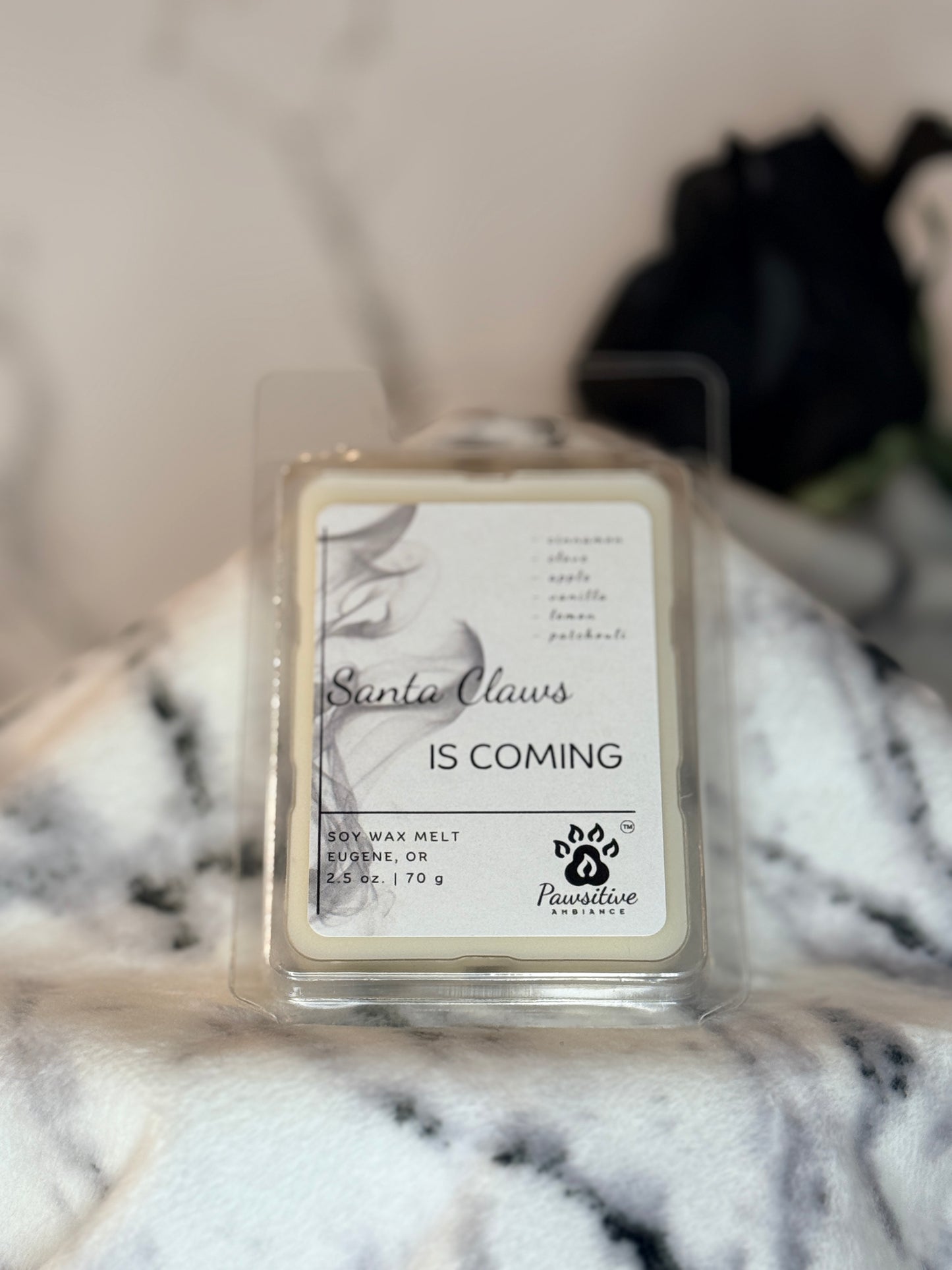 Hand-poured wax melt labeled Santa Claws is Coming featuring notes of cinnamon, clove, apple, vanilla, lemon and patchouli.  2.5 oz. Manufactured by Pawsitive Ambiance.
