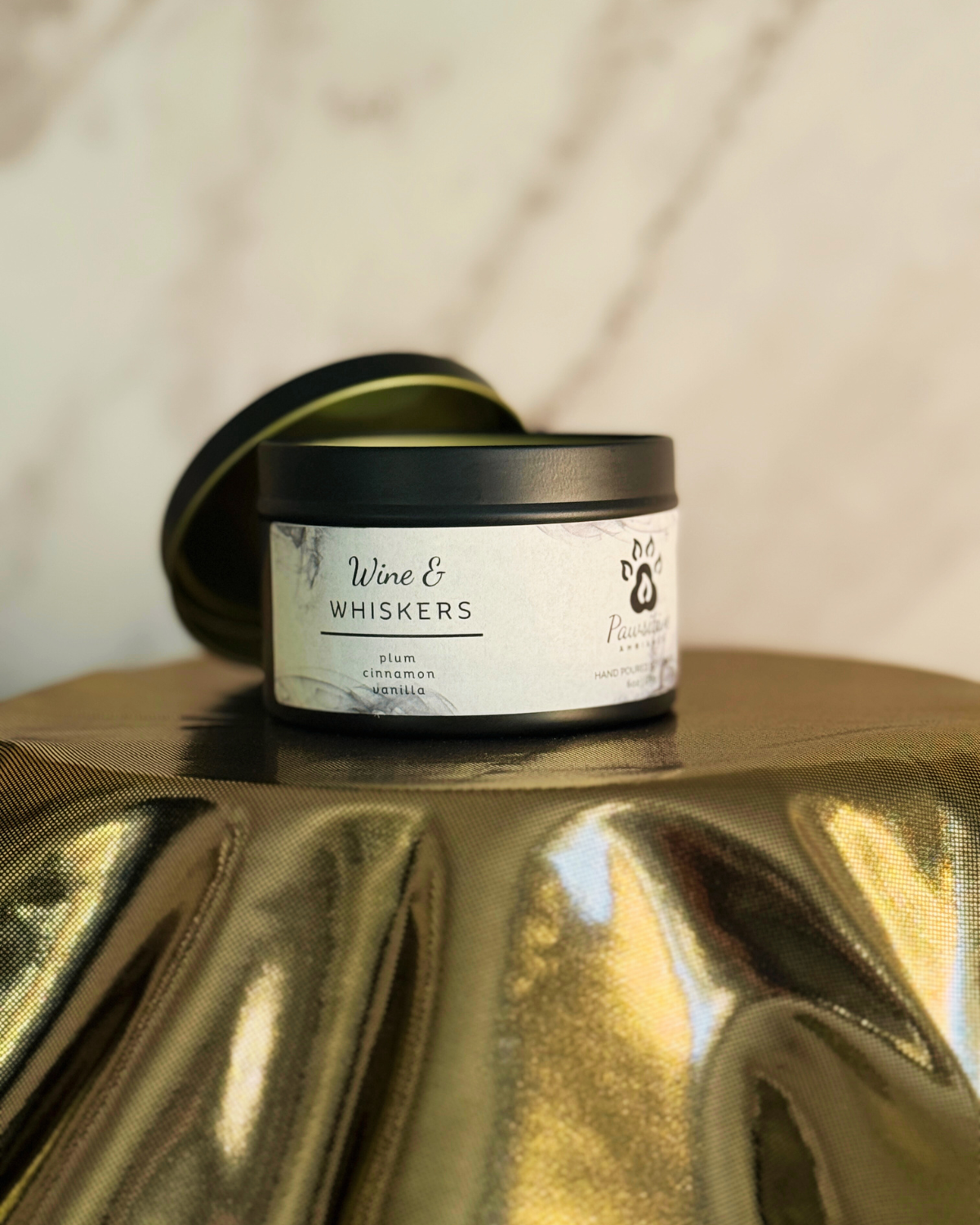 Hand-poured soy candle labeled Wine & Whiskers featuring notes of plum, cinnamon and vanilla.  6 oz. Manufactured by Pawsitive Ambiance.